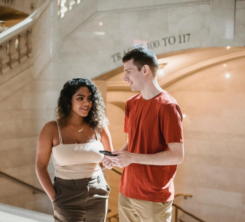 young man and woman talking while outside
